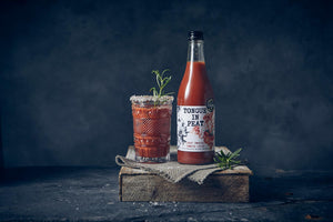 peat smoked tomato juice bottle next to a bloody mary cocktail